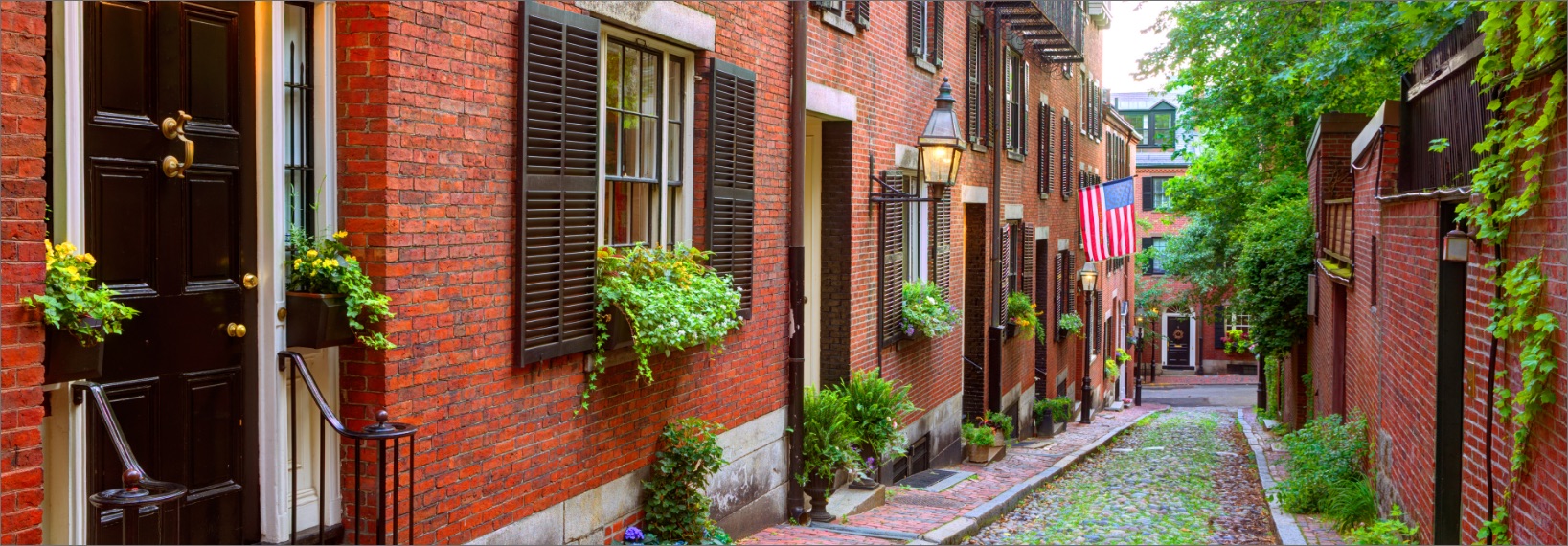 looking down narrow Boston street with brick apartment building on either side 